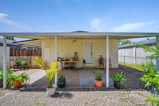 a view of a house with backyard and sitting area
