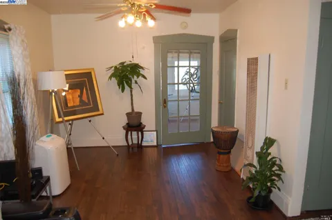 a view of a hallway with wooden floor and a potted plant