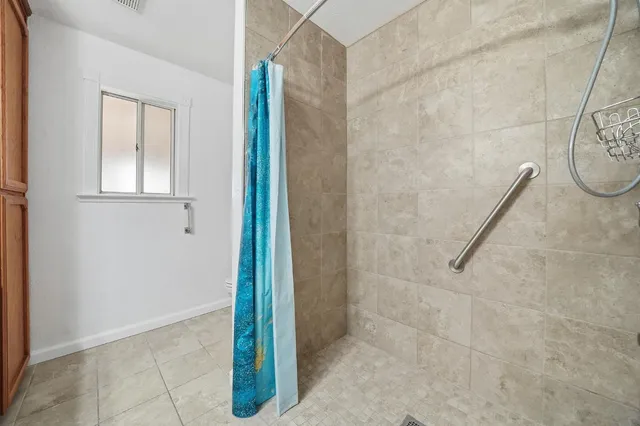 a view of an empty room with wooden floor and a ceiling fan