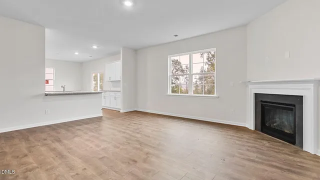 a view of an empty room with a window and fireplace
