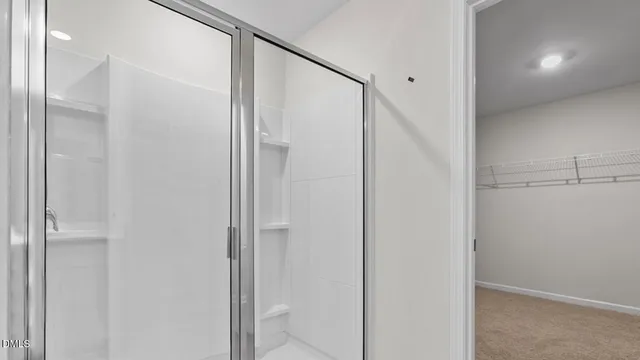 a bathroom with a glass shower door and a glass door