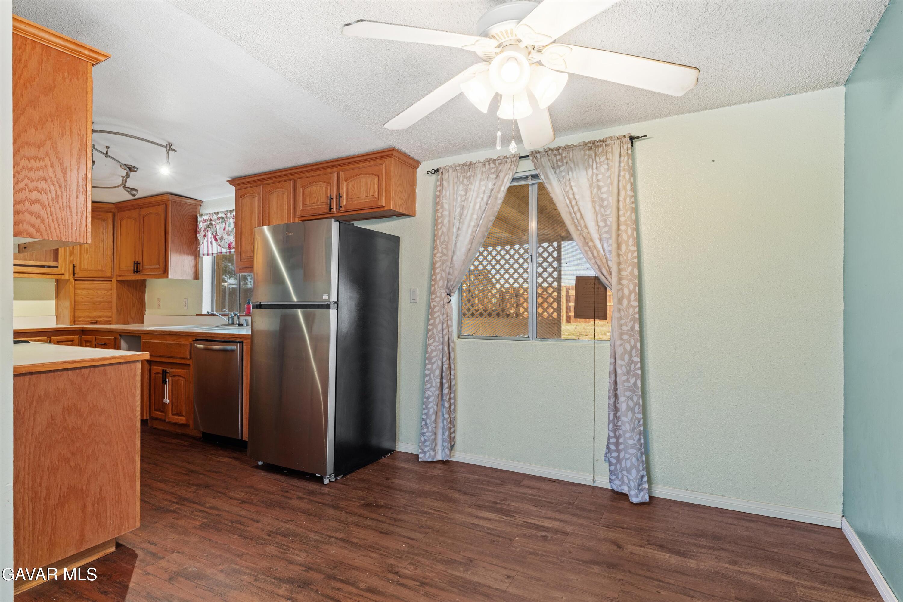 13445 Fran Street North Edwards, CA 93523 - Photo 6 of 27 a view of a kitchen with a refrigerator a ceiling fan and wooden floor