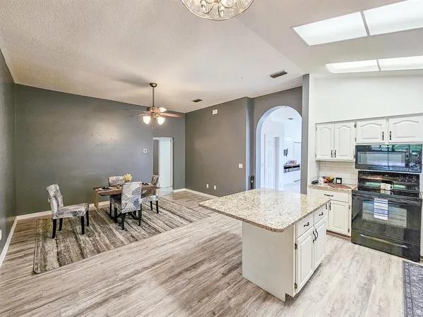 a living room with stainless steel appliances kitchen island granite countertop furniture and a kitchen view