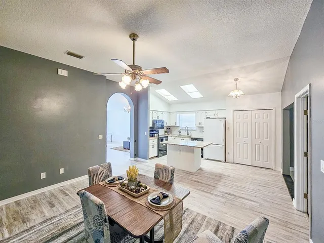 a living room with kitchen island furniture and a chandelier