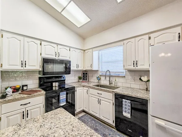 a kitchen with a sink stove top oven and cabinets