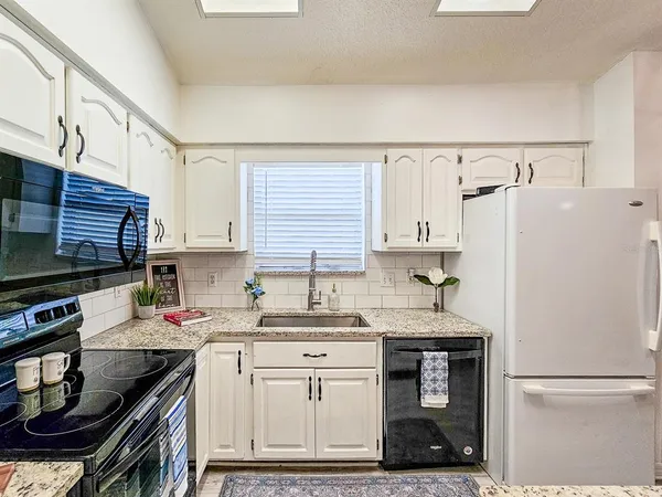a kitchen with appliances a sink and cabinets