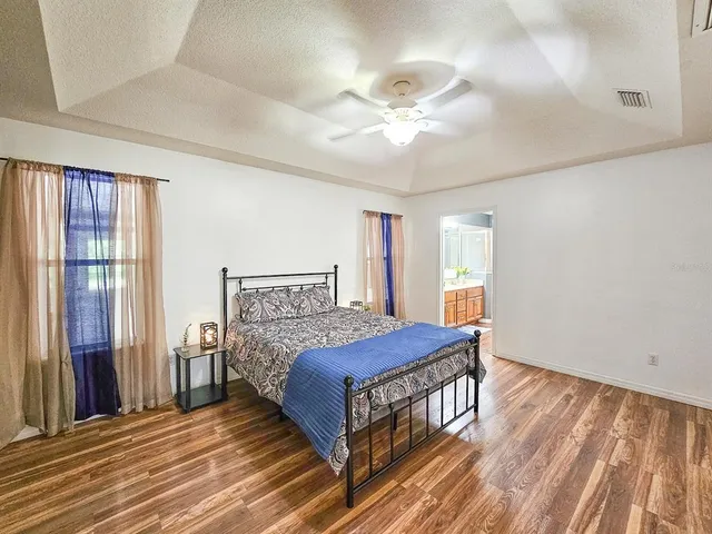 a bedroom with a large bed and a chandelier