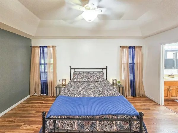a bedroom with a large bed and a chandelier