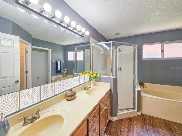 a bathroom with a sink double vanity granite tub shower and mirror