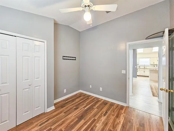 a view of a room with wooden floor and a ceiling fan