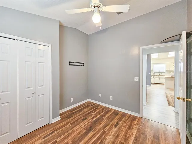 a view of a room with wooden floor and a ceiling fan