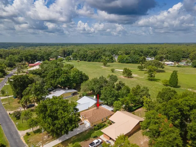 an aerial view of a house with lots of residential buildings and mountain view in back