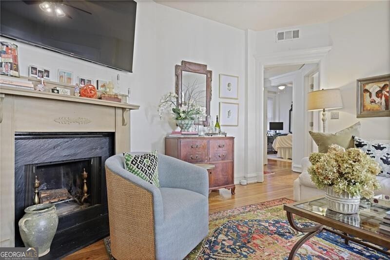 734 Highland Avenue Northeast, Unit 2 Atlanta, GA 30312 - Photo 6 of 24 Living area with a fireplace, wood finished floors, and a ceiling fan