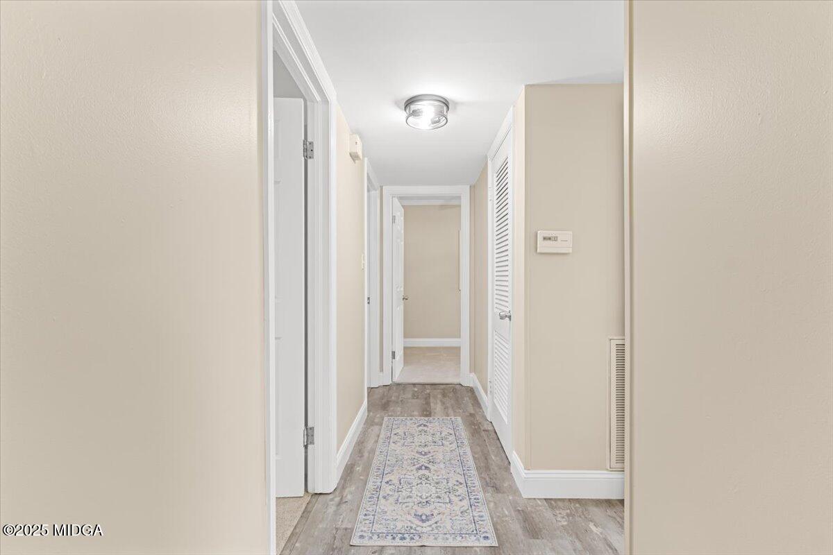 1305 Davis Avenue Perry, GA 31069 - Photo 5 of 26 a view of a hallway with wooden floor and a bathroom