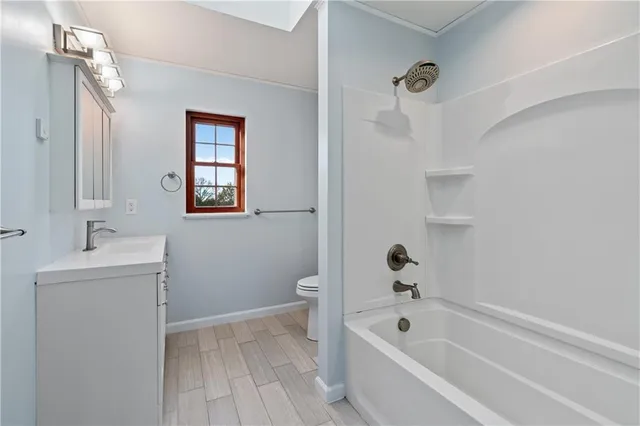 a bathroom with a bathtub sink and mirror