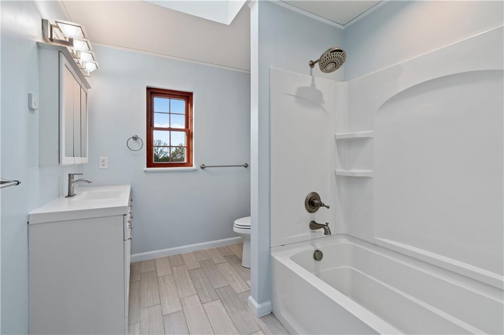 4636 Brownsville Road Pittsburgh, PA 15236 - Photo 21 of 40 a bathroom with a bathtub sink and mirror