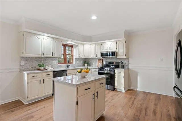 a kitchen with a refrigerator stove top oven and sink