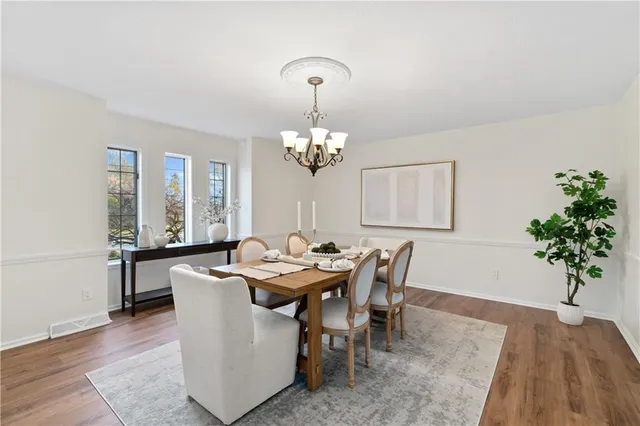 a dining room with furniture potted plants and wooden floor
