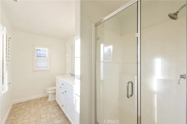 a bathroom with a double vanity sink toilet and shower