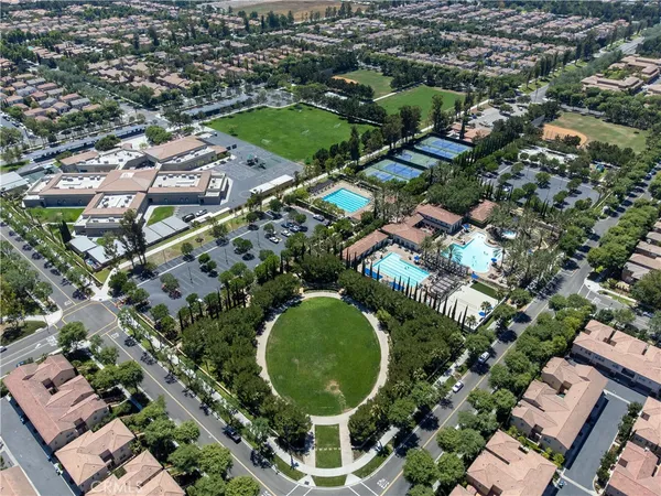 an aerial view of a residential apartment building with a yard and parking spaces