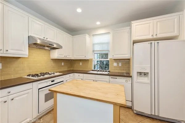 a kitchen with stainless steel appliances granite countertop a refrigerator sink and stove