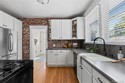 a kitchen with stainless steel appliances granite countertop a stove a sink dishwasher and cabinets with wooden floor