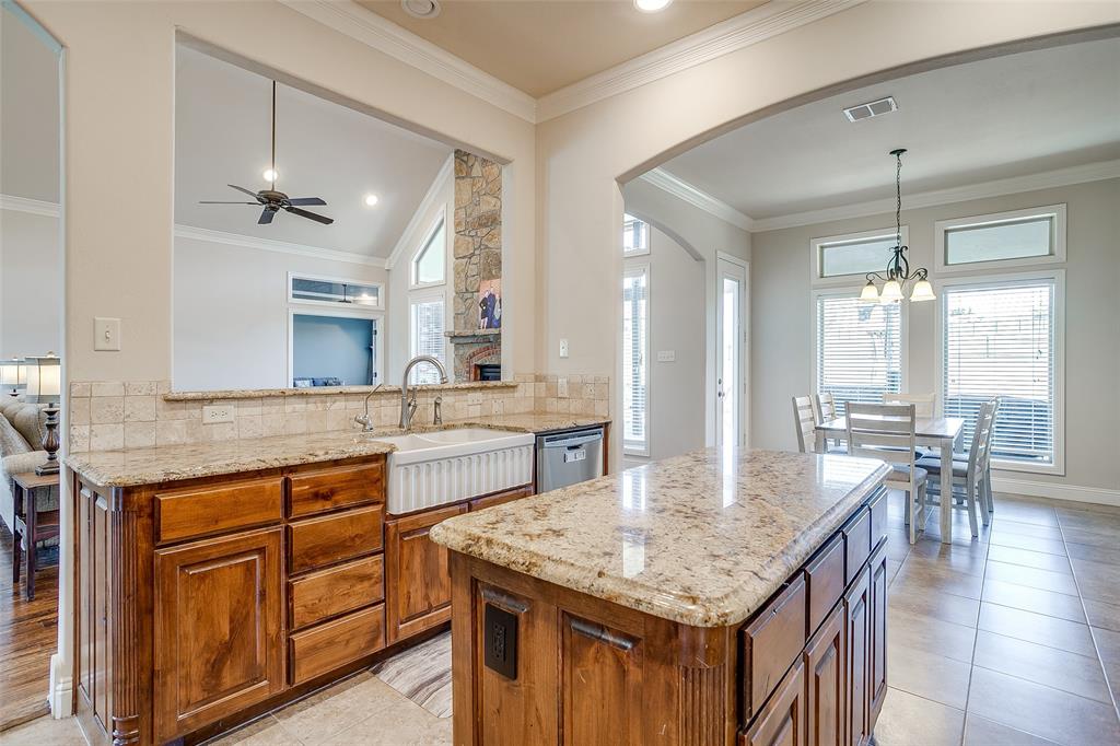 131 Condor View Weatherford, TX 76087 - Photo 11 of 34 a kitchen with granite countertop center island wooden floor stainless steel appliances and living room view