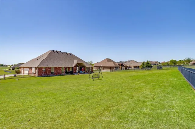 a view of a house with a big yard and large trees