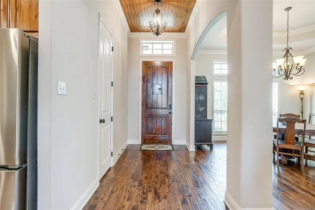 a view of a hallway with wooden floor and dining room view