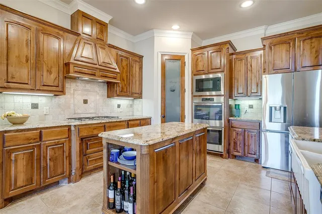 a kitchen with stainless steel appliances granite countertop a stove top oven a refrigerator a sink and dishwasher