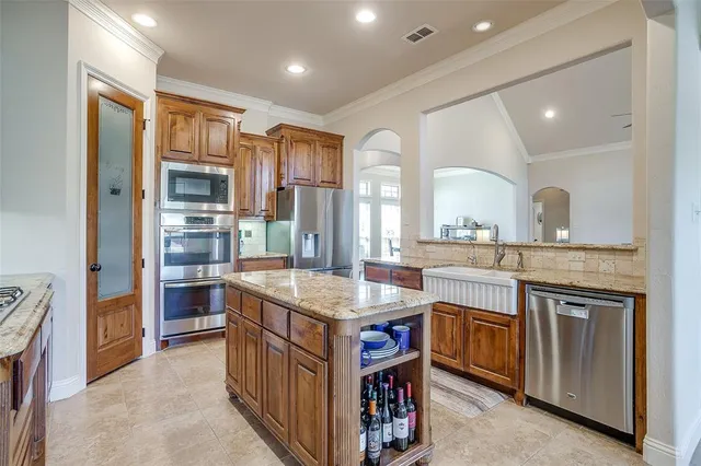 a kitchen with stainless steel appliances granite countertop a stove a sink dishwasher a refrigerator and a oven with wooden floor