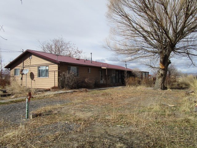 1054-19 19 1/2 Road Fruita, CO 81521 - Photo 17 of 24 a front view of a house with a yard and garage