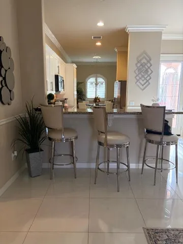 a dining hall with stainless steel appliances a dining table and chairs with kitchen view