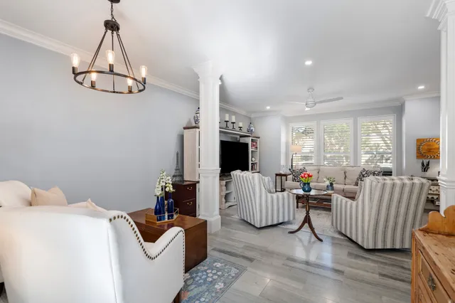 a living room with furniture chandelier and a flat screen tv