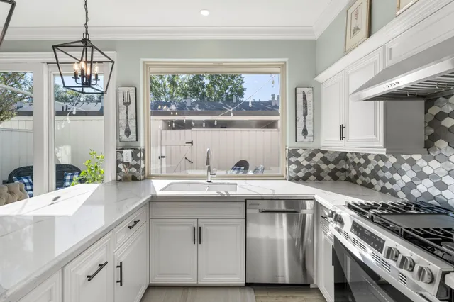 a kitchen with stainless steel appliances granite countertop a sink and a stove