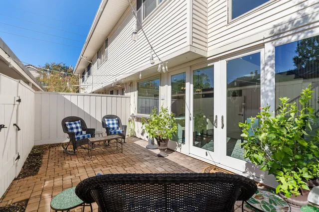a view of a house with patio and wooden fence