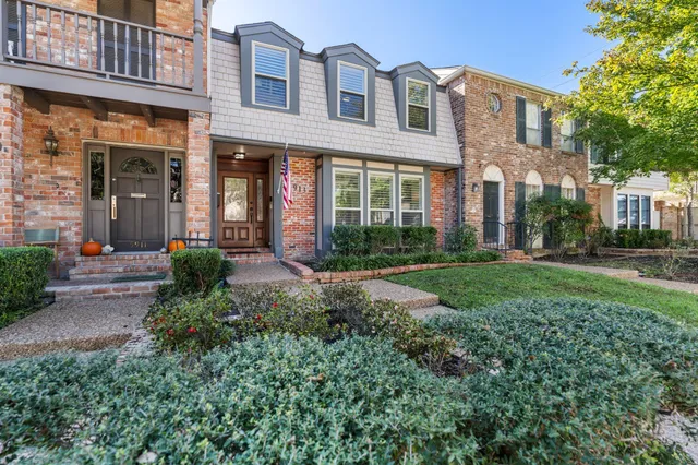 front view of a brick house with a yard