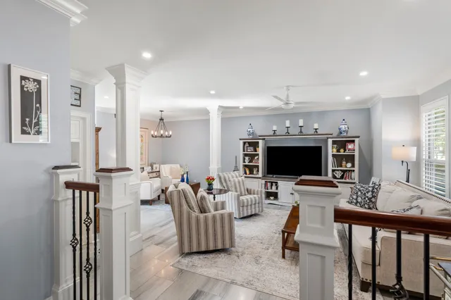 a living room with furniture a flat screen tv and a large window