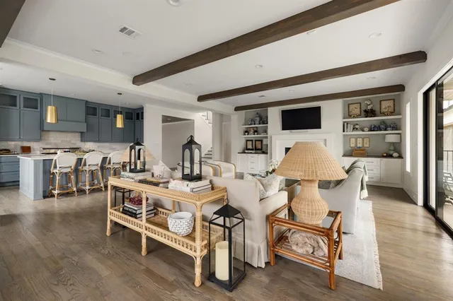 a living room with furniture a table and kitchen view