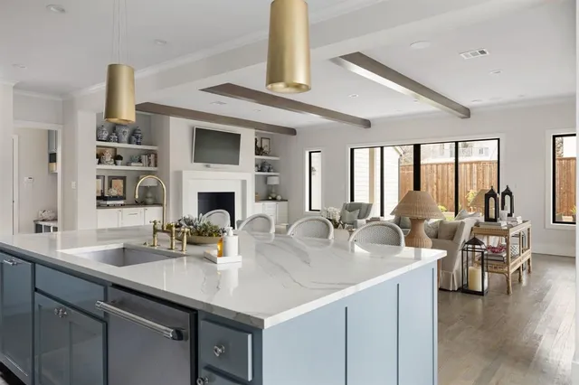a kitchen with a sink dishwasher a dining table and chairs with wooden floor