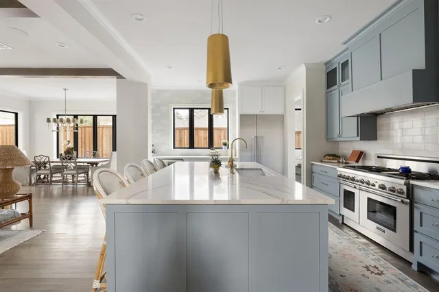 a large kitchen with stainless steel appliances granite countertop a lot of counter space and wooden floors