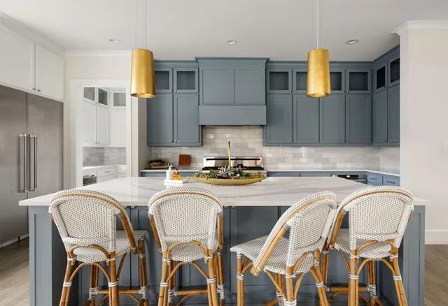 a kitchen with stainless steel appliances granite countertop a table chairs sink and cabinets