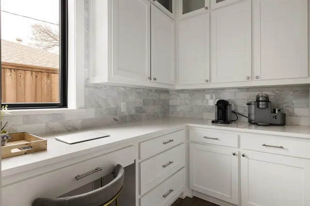 a kitchen with white cabinets and sink