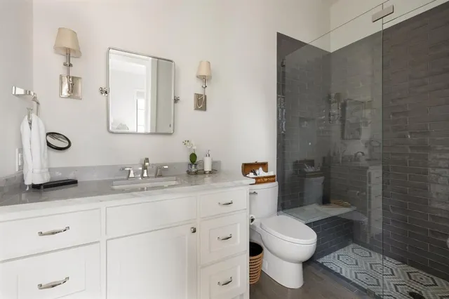 a bathroom with a granite countertop toilet sink and a mirror