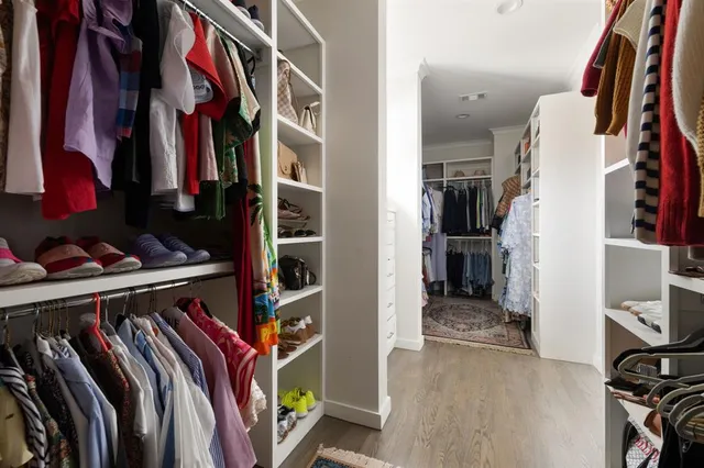 a view of walk in closet with clothes and shoes