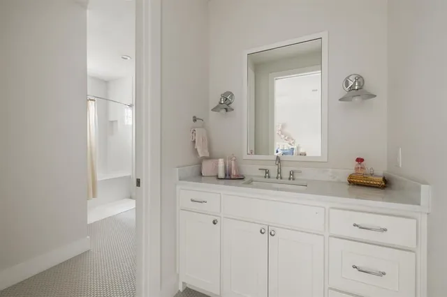 a bathroom with a granite countertop sink and a mirror