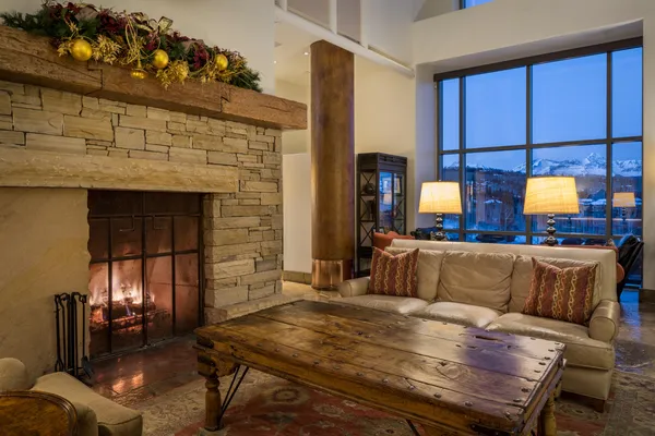 a living room with furniture a chandelier and a fireplace