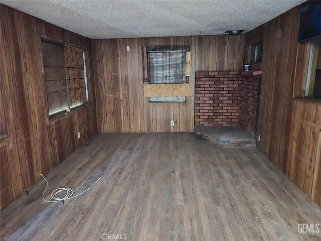 a view of empty room with wooden floor and entryway