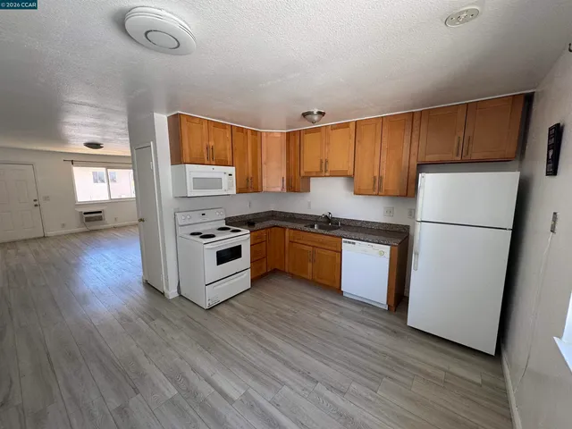 a kitchen with wooden floors and white appliances
