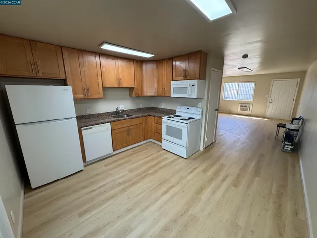 a kitchen with stainless steel appliances granite countertop a refrigerator a stove top oven a sink and dishwasher